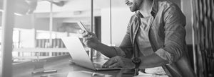 Black and white image of man on computer 